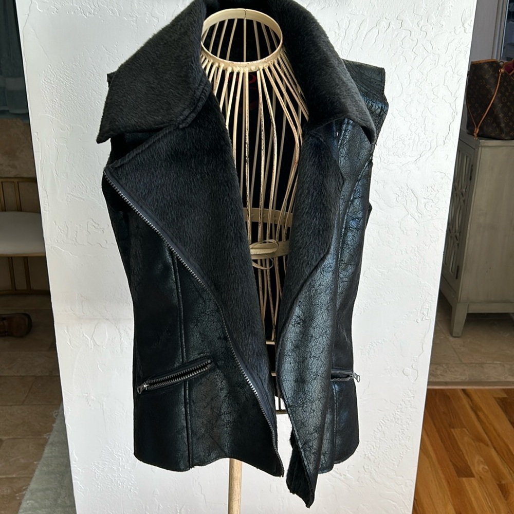 Black faux leather vest with metallic hue and faux fur inside.